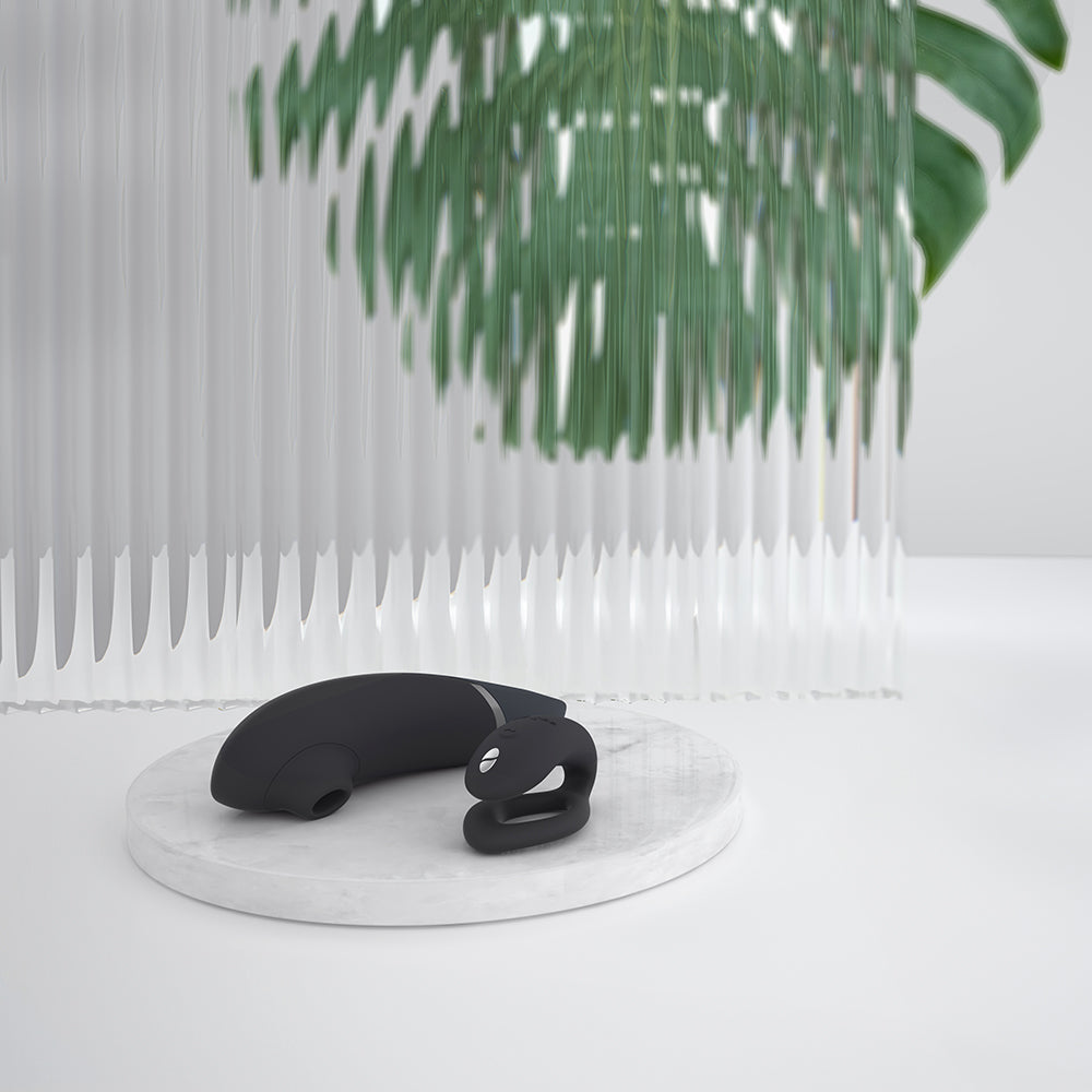 Black silicone product on a white platform with green leaves in the background